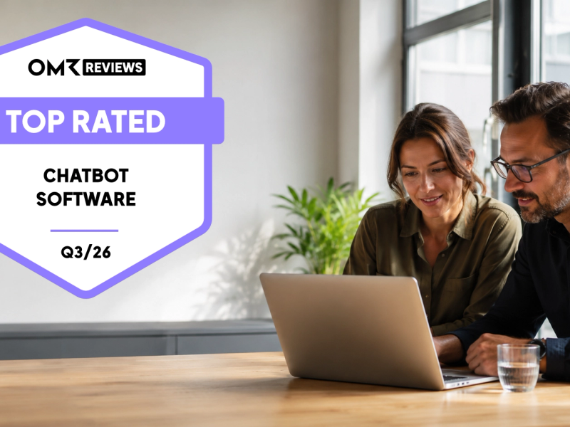 Zwei Personen arbeiten gemeinsam an einem Laptop, links davon das OMR Reviews Top Rated Chatbot Software Q3/26 Badge.